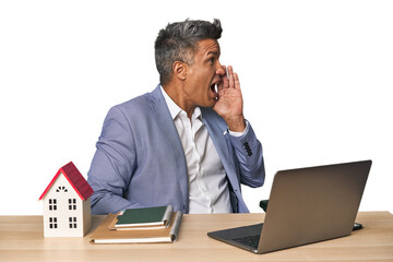 Middle-aged Hispanic businessman with real estate theme shouting and holding palm near opened mouth.