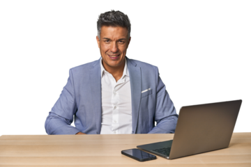 Elegant businessman at desk with laptop confident keeping hands on hips.