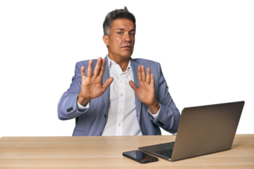 Elegant businessman at desk with laptop being shocked due to an imminent danger