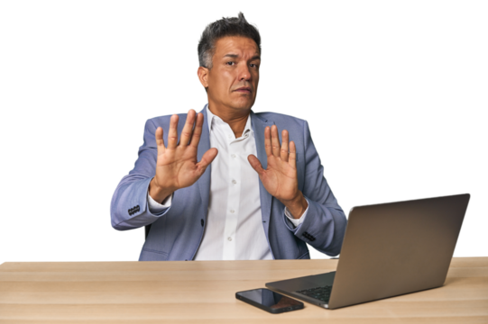 Elegant businessman at desk with laptop being shocked due to an imminent danger
