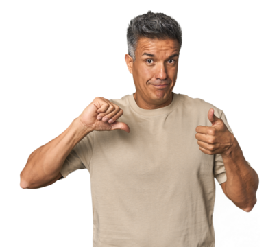 Middle-aged Latino man showing thumbs up and thumbs down, difficult choose concept