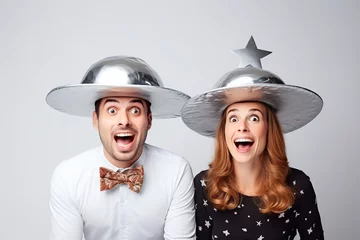 Foto op Canvas man and woman holding metallic hats, exaggerated emotions, futuristic spaceship, ufos in the sky, conspiracy theory concept © zgurski1980