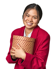 Young Chinese woman holding a heart-filled box laughing and having fun.