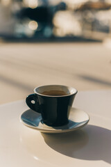 Cup of black coffee on a table in a street cafe.
