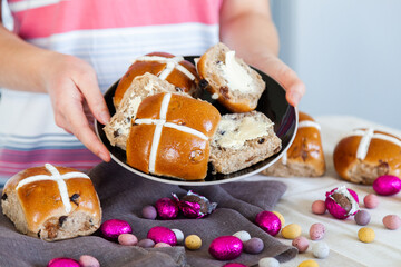 Buttered hot cross buns and scattered eggs at Easter on a plate
