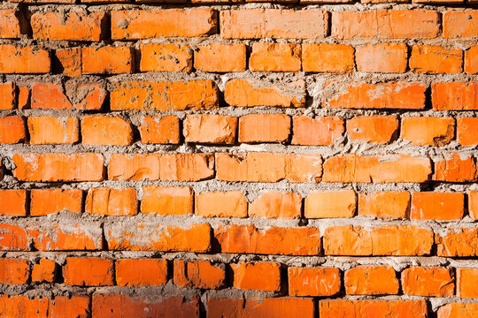 grungy pattern of an orange brick wall. not finished or abandoned architecture development concept. dirty and uneven texture