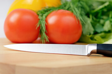 Chopping board with tomato, parsley and knife
