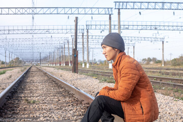 Asian man sit on the tracks, railway road