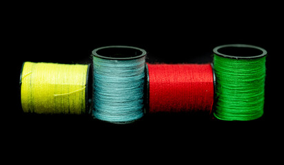 spools of thread on a black background of different colors