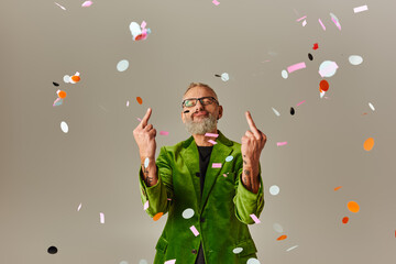 good looking funky mature man in green blazer showing middle fingers at camera with closed eyes