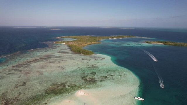 Sand bar reef flat and drop off with boats driving in the deeps between coves