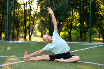 A man is doing yoga. Young man training. A handsome young man goes in for sports. Yoga classes in nature. Man stretching in nature. doing handstand yoga asana.