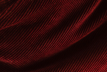 Surface burgundy corduroy fabric with darkening folds
