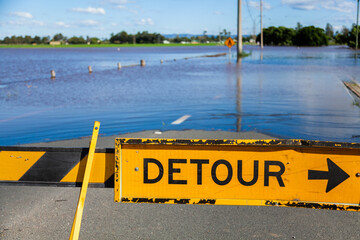 Detour signs blocking a flooded roadway