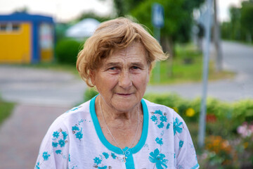 Old woman in the garden. Selective focus.
