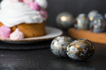 Beautiful stylish still life. Easter cake with meringue, marshmallows, and Easter eggs on a dark background. happy Easter 2024.