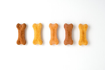 Line of bone shaped dog biscuits over white. Dog treats