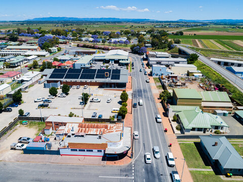Aerial view of street lined with shops and businesses at the edge of country town