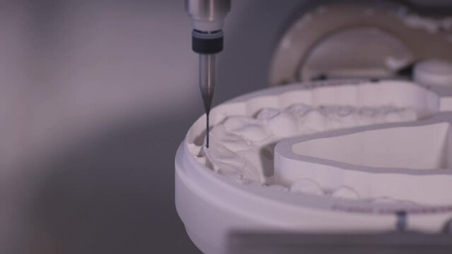 Close up. Professional CNC dental milling machine carving out shape of artificial teeth in the dental lab. One of the steps in making of artificial teeth by dental technician in the clinic.