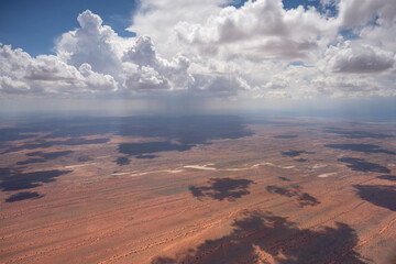 cumulus clouds and rain shower on dune stripes of Kalahari, east of Pokweni, Namibia