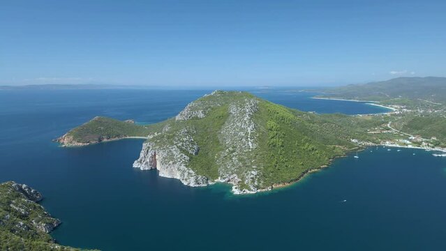 Cinematic rotating up high 4K drone clip over the tropical blue waters of Toroni in Chalkidiki with some boats passing by