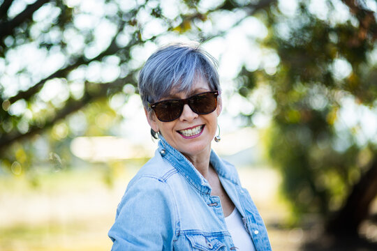 portrait of a senior woman in the garden wearing sunglasses