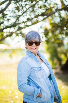 portrait of a senior woman in the garden wearing sunglasses
