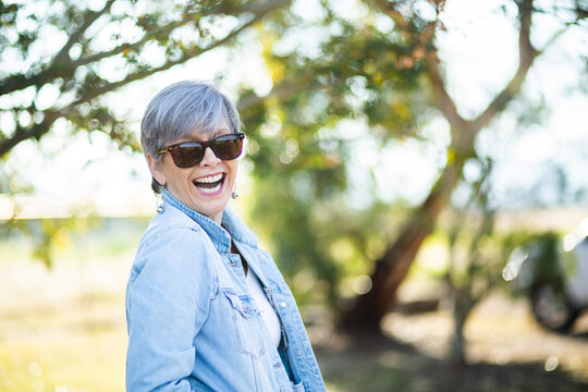 portrait of a senior woman in the garden wearing sunglasses