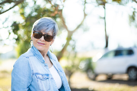 portrait of a senior woman in the garden wearing sunglasses