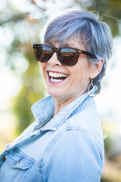 portrait of a senior woman in the garden wearing sunglasses