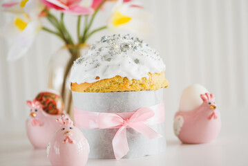 Traditional Easter cakes or sweet bread with hen figurines and eggs on white table. Front view