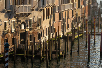 Fototapeta na wymiar Morning Gold light over Old Small Piers for Gondolas in Venice - Scenic detail of the Lagoon City