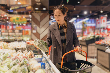 Elegant Woman Selecting Fresh Vegetables at Supermarket