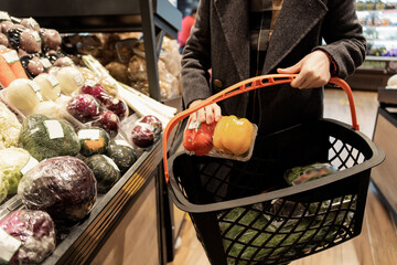 Consumer Selecting Fresh Peppers at Grocery Store