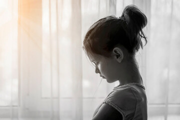 Depressed Lonely Sad Upset  Teenager Girl Alone on Black White Window Background with Glimmer of...