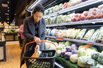 Woman Selecting Fresh Vegetables in Supermarket Aisle