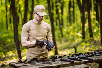 guy in the woods tests his weapons for shooting sports