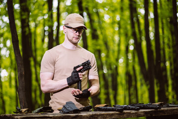 guy in the woods tests his weapons for shooting sports