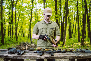 guy in the woods tests his weapons for shooting sports