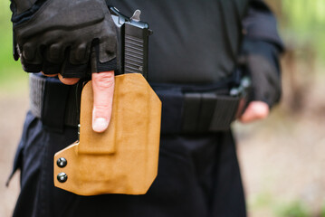 the guy puts the gun in the holster close-up
