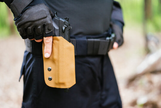 the guy puts the gun in the holster close-up