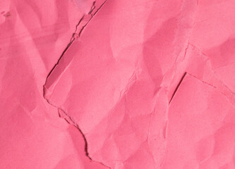 A photo of torn and wrinkled pink paper forms a background