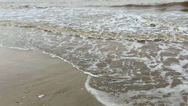 Empty beach with muddy sea water