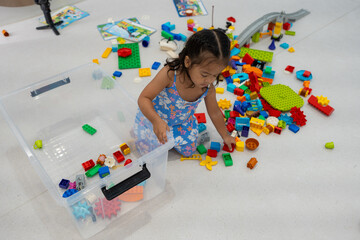 Cute asian little girl playing with colorful toy blocks at kindergarten daycare, Toddler kid in...