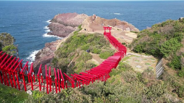 Drone aerial view of a seaside shrine with a large number of red torii gates (Shinto shrine archway) at Motonosumi Shrine, Yamaguchi Prefecture, Japan,