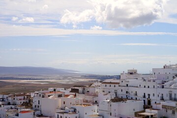 Fototapeta na wymiar view over the roofs of the white Andalusian houses in Vejer de la Frontera towards the Cultivos piscicolas de Barbate and the Atlantic Ocean at the horizon, Andalusia, Costa de la Luz, Spain