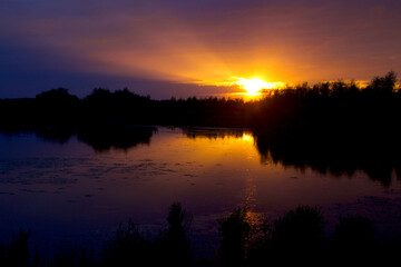 Sunbeams out of the cloud cover at sunset over the lake