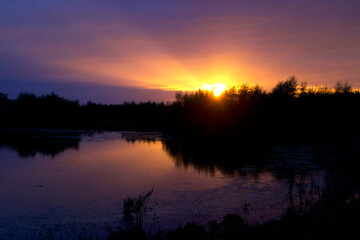 The sun breaks out under cloud cover just before dusk