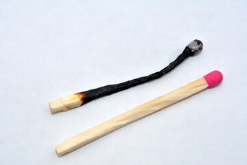 Macro photo of a burnt match and a whole red match
