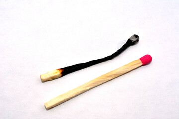 Macro photo of a burnt match and a whole red match